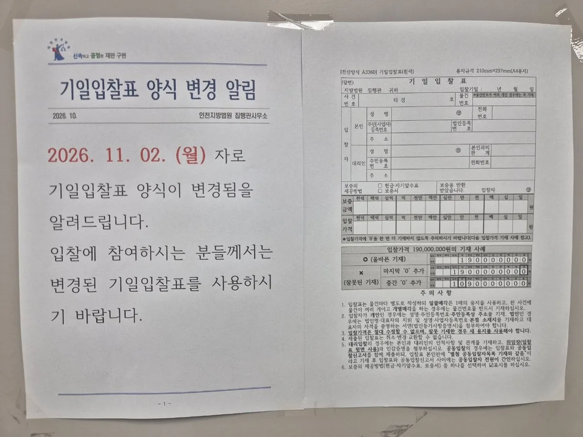기일입찰표 양식 변경 알림 내용과 기일입찰표 서식 견본이 나란히 인쇄된 문서가 붙어 있다.